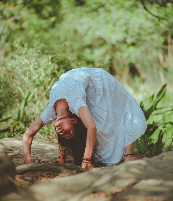 Woman in a calm, seated yoga pose in a dark, serene environment.